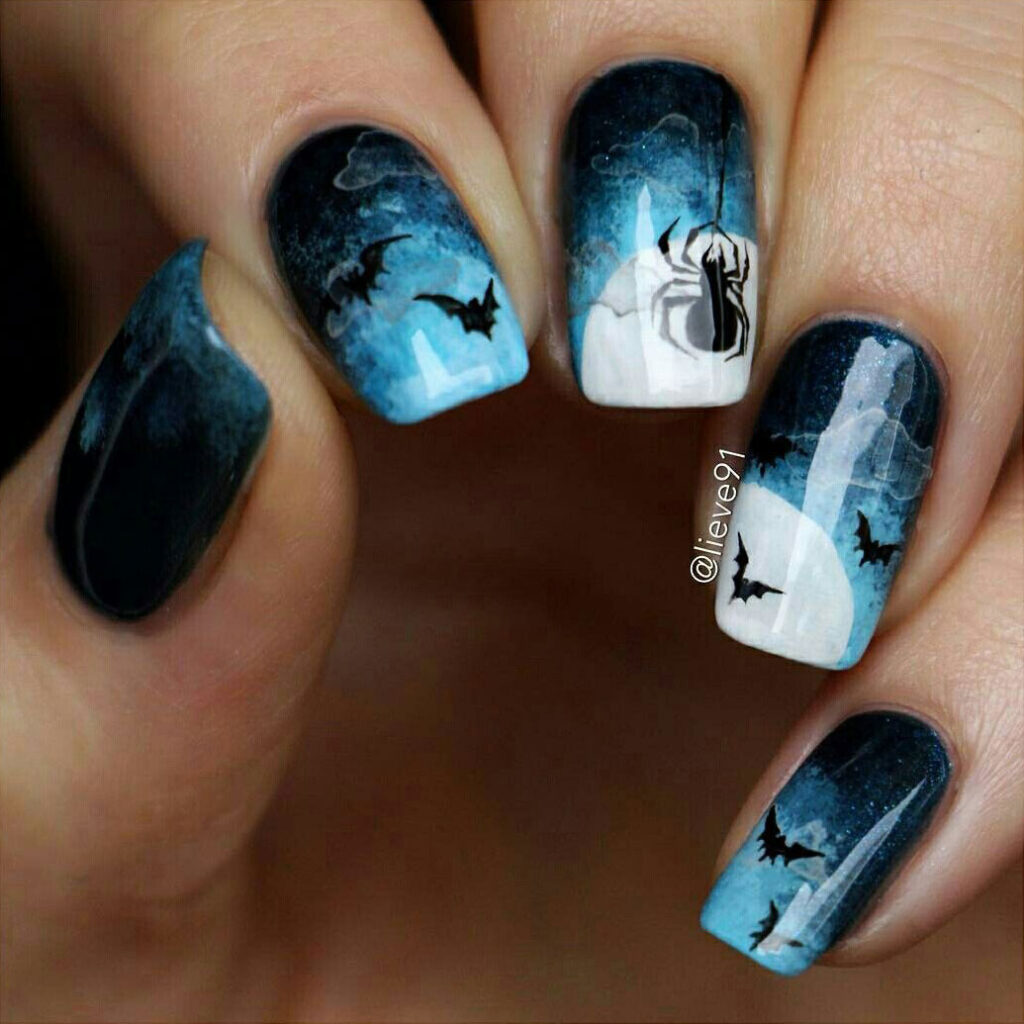 Hand with nails with art of night sky with bats and spiders.