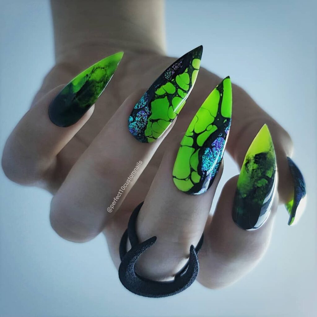 Blue and green almond long nails with an alien pattern.