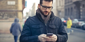 A man on the street looking on his phone